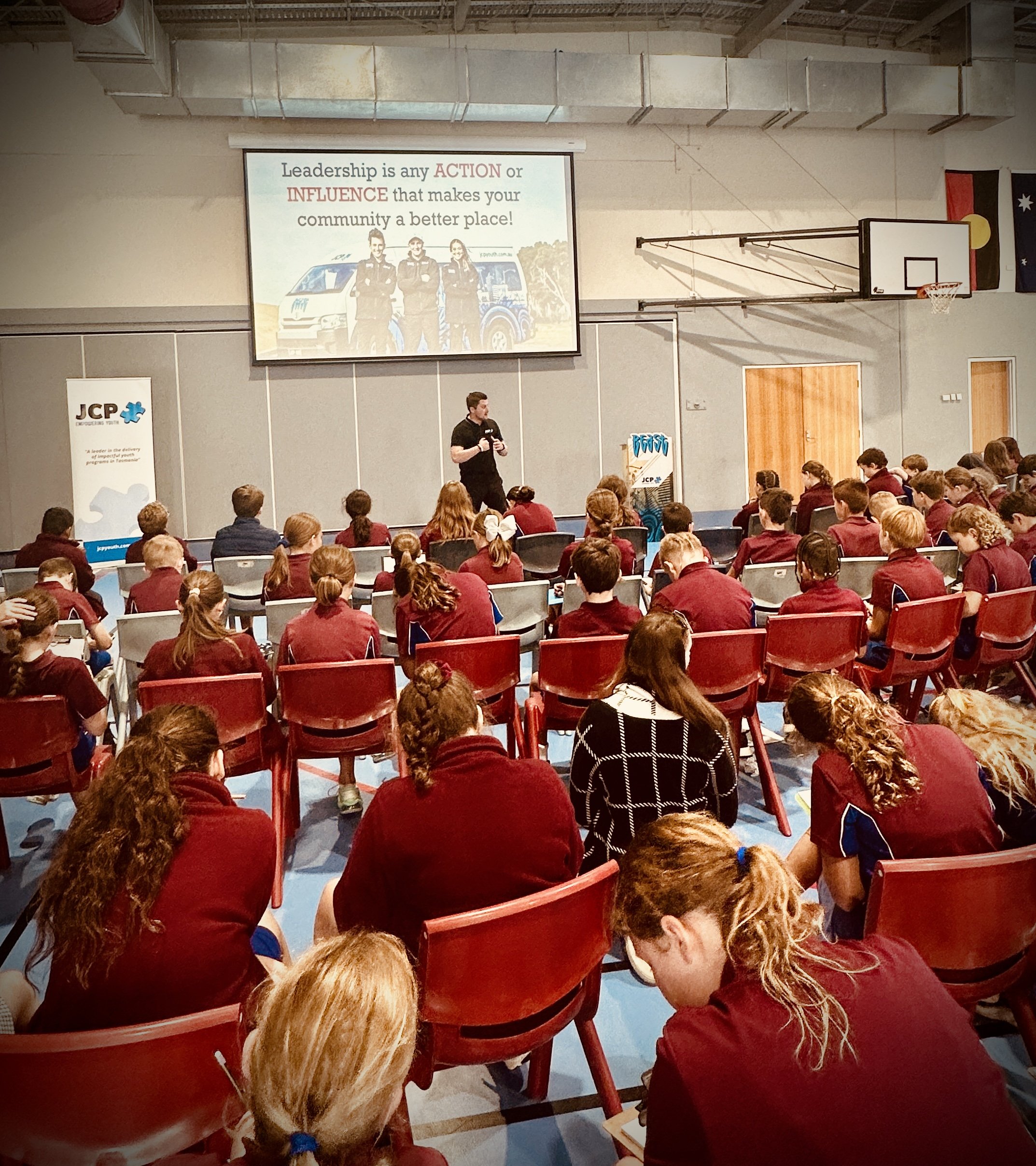 A JCP Youth presenter speaking to students at a school.
